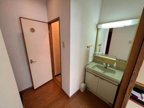a bathroom with a green sink and a mirror at Sapporo's Secret Onsen Sanctuary Marukoma Onsen Ryokan in Chitose