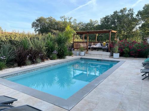 - une piscine dans une cour avec un kiosque dans l'établissement Villa SOANNE, à Bagnols-en-Forêt