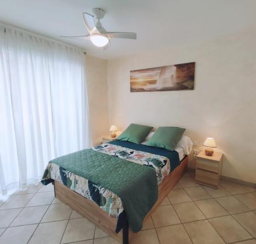 une chambre avec un lit et un ventilateur de plafond dans l'établissement T2 CALME + cadre verdoyant, à Besse-sur-Issole