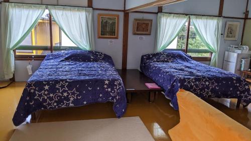 a bedroom with two beds and two windows at Pension Alba - Vacation STAY 70972v in Tateyama