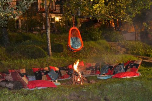 a fire in the grass next to a group of couches at Sparsh Resort, A Boutique Stay - Just 2kms uphill from Mall Road, near Old Manali in Manāli