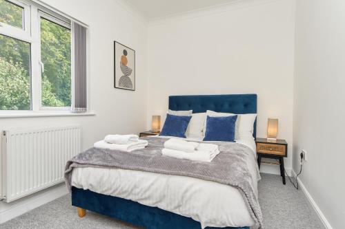 文特諾的住宿－Stunning 3 Bed Apt With Countryside Views & Parking - Ideal For Families, Groups & Business Stays - Close To Ventnor, Shanklin & Sandown，卧室配有蓝色和白色的大床