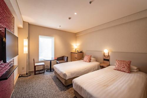 a hotel room with two beds and a table at Kyoto Tokyu Hotel in Kyoto