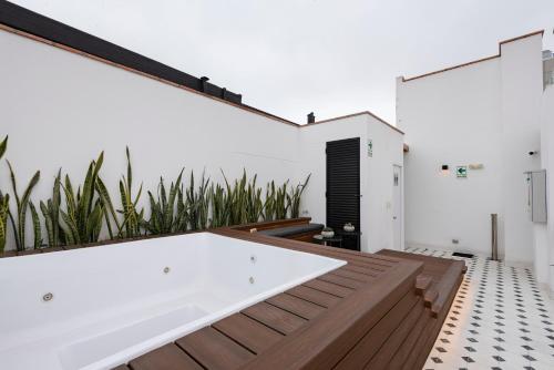 a bath tub sitting on a wooden deck in a bathroom at Stunning Modern 1BD Apartment in Barranco in Lima