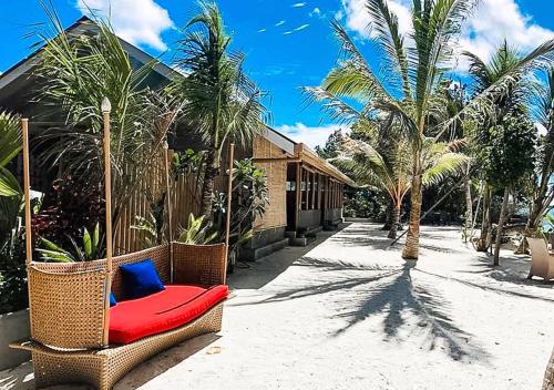 a wicker chair sitting in a courtyard with palm trees at Tropical Tree in Fehendhoo