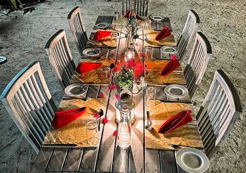 a long wooden table with red napkins on it at Tropical Tree in Fehendhoo