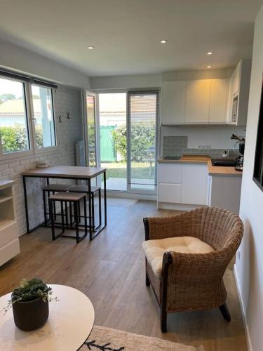 une cuisine et un salon avec une table et des chaises dans l'établissement Joli appartement avec jardin à 400m de la plage, à Anglet