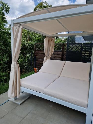 un letto sotto un baldacchino su un patio di Comfortable flat with garden a Poznań