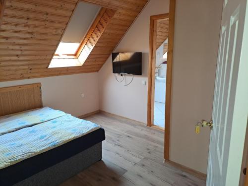 a bedroom with a bed and a television in it at Alinka Apartmanház in Balatonlelle