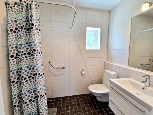 a bathroom with a toilet and a shower curtain at Åminne Fritid & Havsbad AB in Åminne