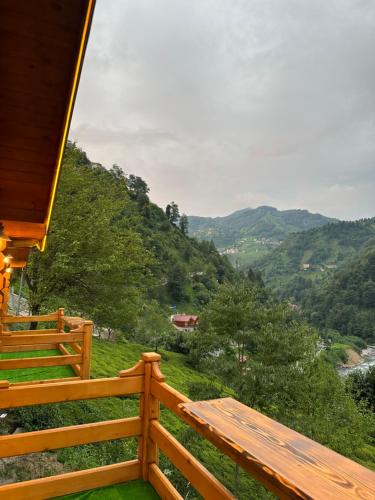 a wooden porch with a view of a mountain at Maysa Suit Bungalov in Çamlıhemşin