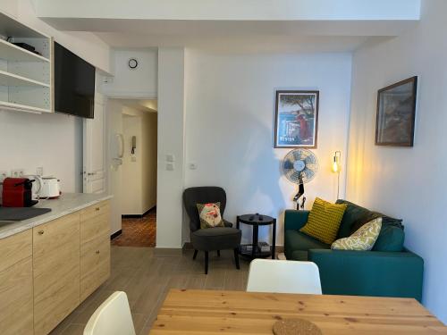 un salon avec un canapé bleu et une chaise dans l'établissement MAGNIFIQUE 3p VUE MER À 5 MIN DE LA PLAGE, à Menton