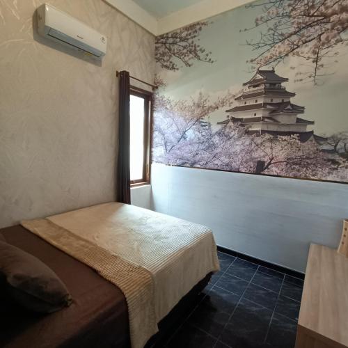 a room with a bed and a painting on the wall at Unique Homestay 443 in Yogyakarta
