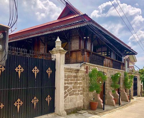 a building with a black gate and a fence at Posada La Patriciana in Taal