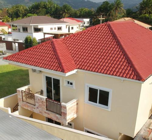 an image of a house with a red roof at Maho's Apartamentos in Tela