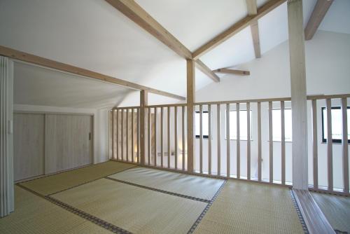 a large room with wooden ceilings and windows at Rainbow Village（レインボーヴィレッジ） in Mihama