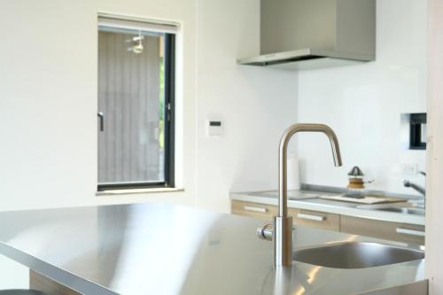 a kitchen with a stainless steel sink and a counter at Rainbow Village（レインボーヴィレッジ） in Mihama