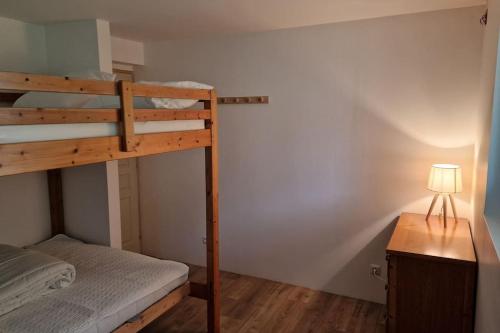 una camera con letto a castello e scrivania con lampada di Ariège, agréable T2 en bord de rivière a Vicdessos