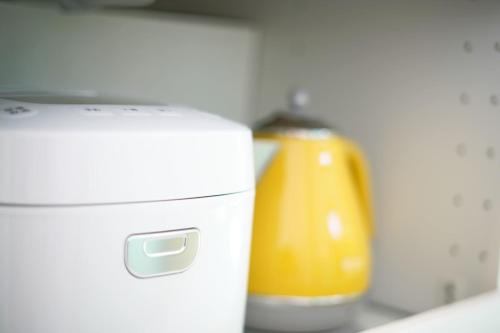 a white toaster sitting next to a yellow appliance at Rainbow Village（レインボーヴィレッジ） in Mihama