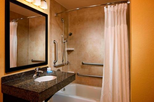 a bathroom with a sink and a tub and a shower at Fairfield Inn & Suites Houston Intercontinental Airport in Houston