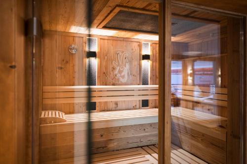 una sauna con paredes de madera y una puerta de cristal en Hotel Stubaierhof, en Neustift im Stubaital