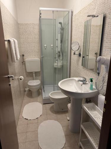a bathroom with a toilet and a sink and a shower at Albergo al lago in Anfo