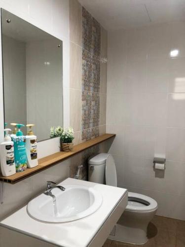 a bathroom with a sink and a toilet and a mirror at Maruay Living Apartment 401 (Khaosan/Chinatown/Samyot MRT) in Bangkok