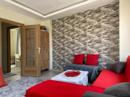 a living room with red furniture and a brick wall at Herold's Guesthouse in Umraniye