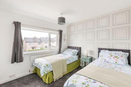 two beds in a room with a window at Entire Charming 5-Bed House in Darwen Blackburn BB1 Free Parking Roadside in Rishton