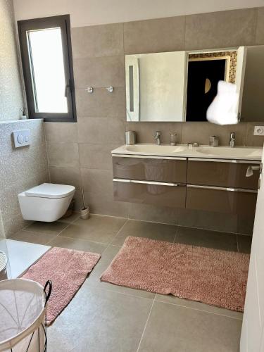 a bathroom with a sink and a toilet and a mirror at VILLA TRANQUILLE in Fréjus