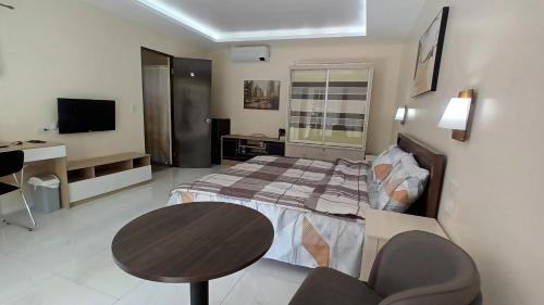 1 dormitorio con cama, mesa y escritorio en Villa Shangri-La en Dumaguete