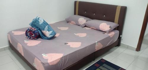 uma cama com almofadas cor-de-rosa da Hello Kitty em HOMESTAY BUDGET MASJID TANAH PERDANA em Masjid Tanah