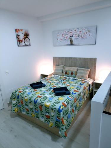 a bedroom with a bed with a colorful comforter at Apartamentos ZANCA CITY CENTER in Málaga