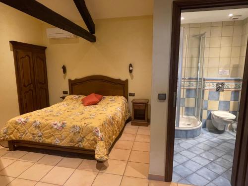 a bedroom with a bed and a bathroom with a toilet at Les Magnolias in Plaisance
