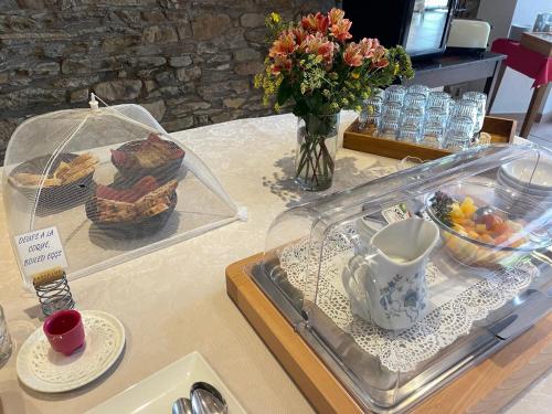 a table with a tray of food and a vase of flowers at Les Magnolias in Plaisance