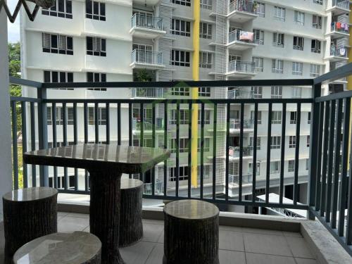 un balcone con tavolo, sgabelli e un edificio di 3R@7pax++ Spacious Space Putrajaya. a Putrajaya