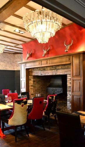 a dining room with a fireplace and tables and chairs at The Bull Inn in Mildenhall