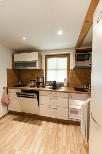 a kitchen with white appliances and a wooden floor at Chalets Lampllehen in Marktschellenberg