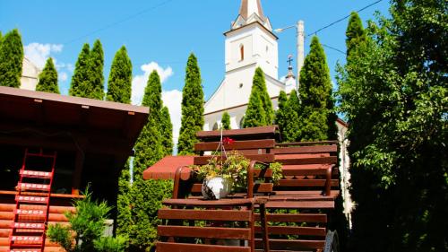 una panchina con un vaso di fiori seduta davanti a una chiesa di Casa Guşă a Borsa