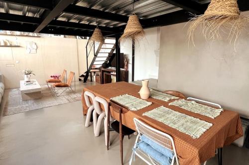 une salle à manger avec une table et des chaises en bois dans l'établissement Loft familial avec grand jardin verdoyant, à Paris