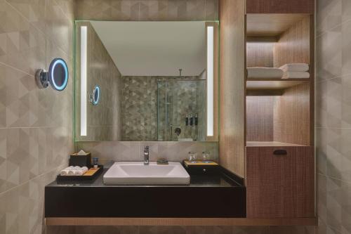 a bathroom with a sink and a mirror at Four Points by Sheraton Desaru in Desaru