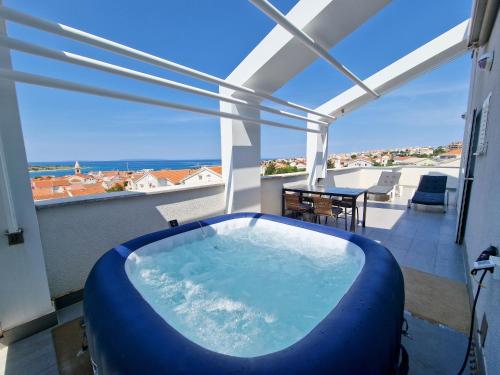 a hot tub on a balcony with a view of the ocean at Vila Novak in Novalja
