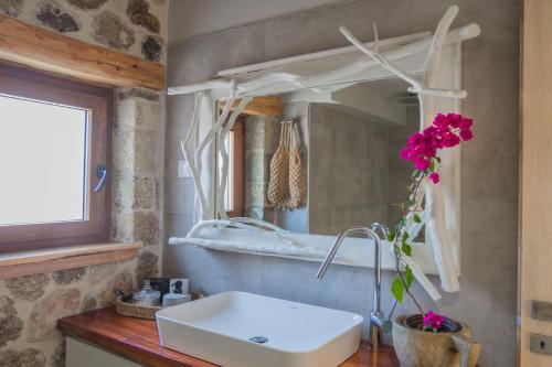 une salle de bain avec un lavabo et un miroir dans l'établissement Kidoni cottage, à Doukádes