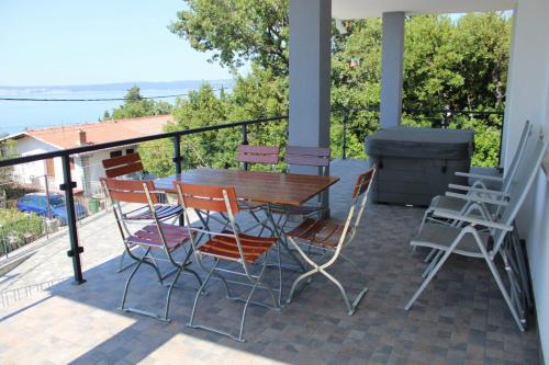 eine Terrasse mit einem Tisch, Stühlen und einem Grill in der Unterkunft Apartment INES 2 with terrace, sea view, Jacuzzi, outdoor pool in Novi Vinodolski