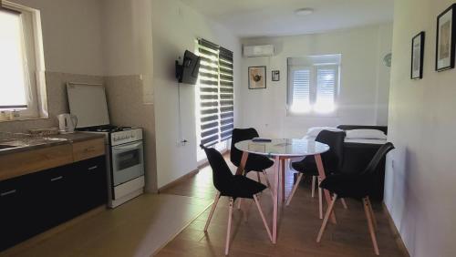 a kitchen with a table and chairs in a room at Apartman MatiNik1 in Gornja Toplica