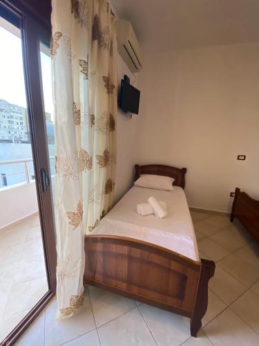 a small bed in a room with a window at VIOLCA GUEST HOUSE in Durrës