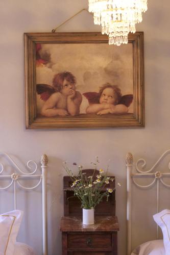 a painting of three angels hanging on a wall at Casa Rural Melitón in Povedilla