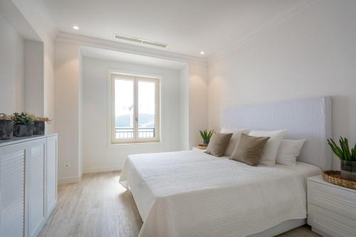 - une chambre blanche avec un lit blanc et une fenêtre dans l'établissement Lustica Bay Apartment Maria By 2bhome, à Radovići