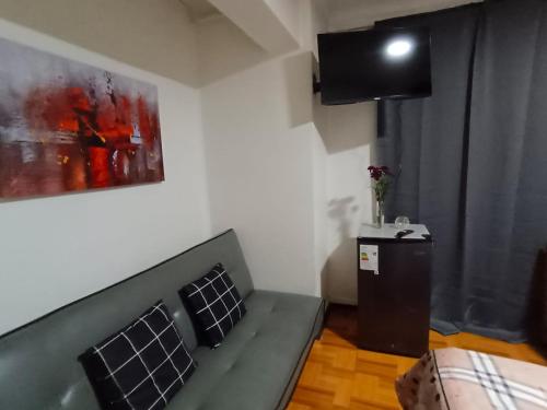 a small living room with a couch and a television at Donde Gabriel in Chillán