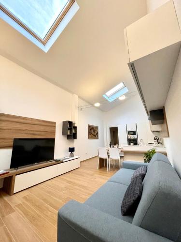 a living room with a blue couch and a tv at Home Viale Trento 16 in Cagliari